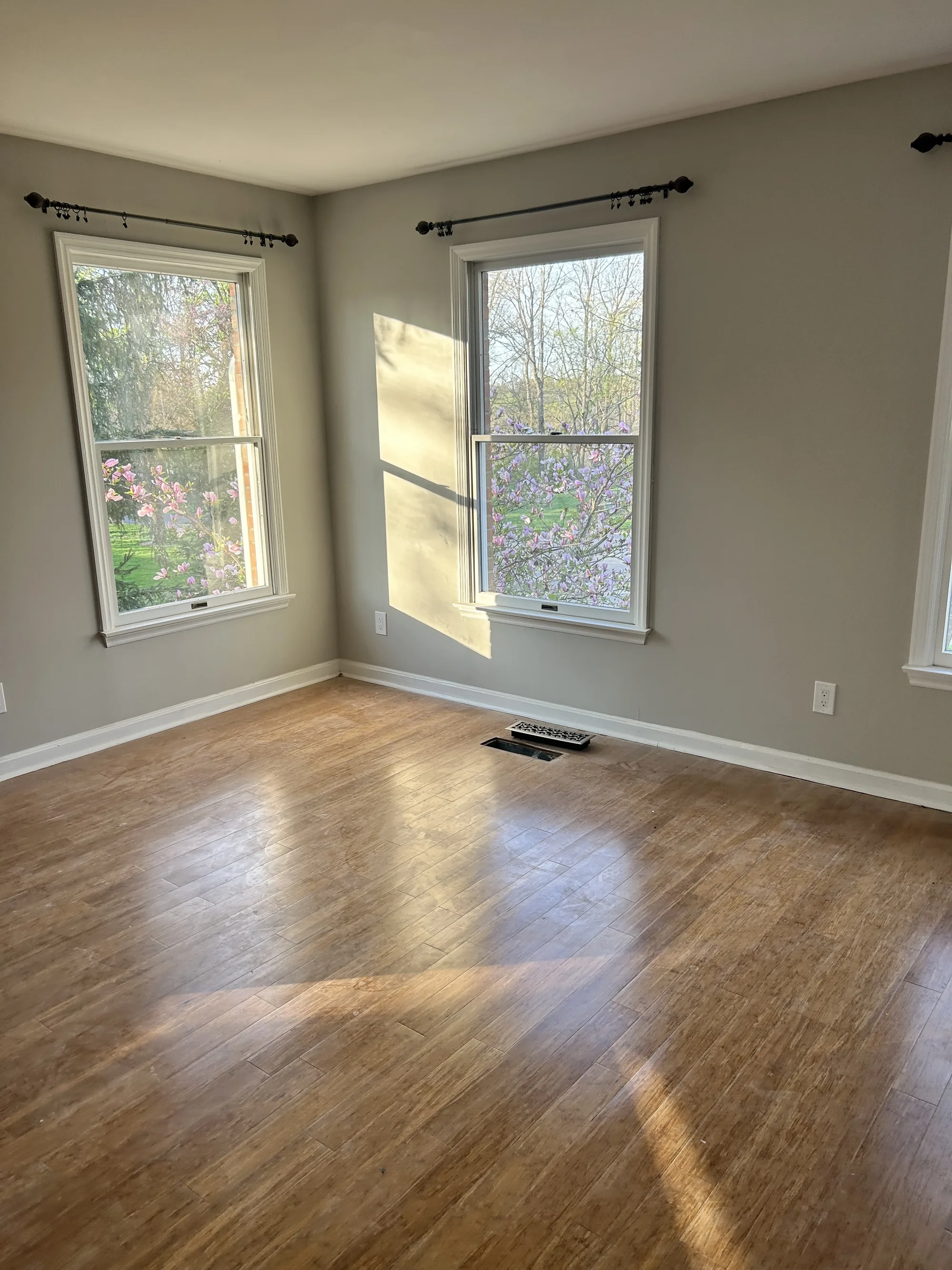 Empty, sunlit room with clean hardwood floors ready for a new tenant in Cincinnati