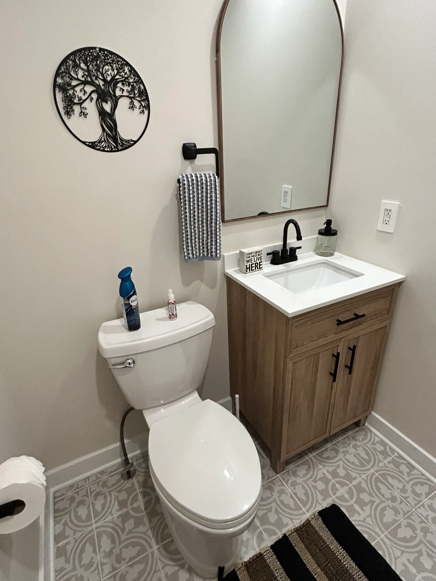 Fresh, spotless powder room with a wood vanity and patterned tile floor in Cincinnati
